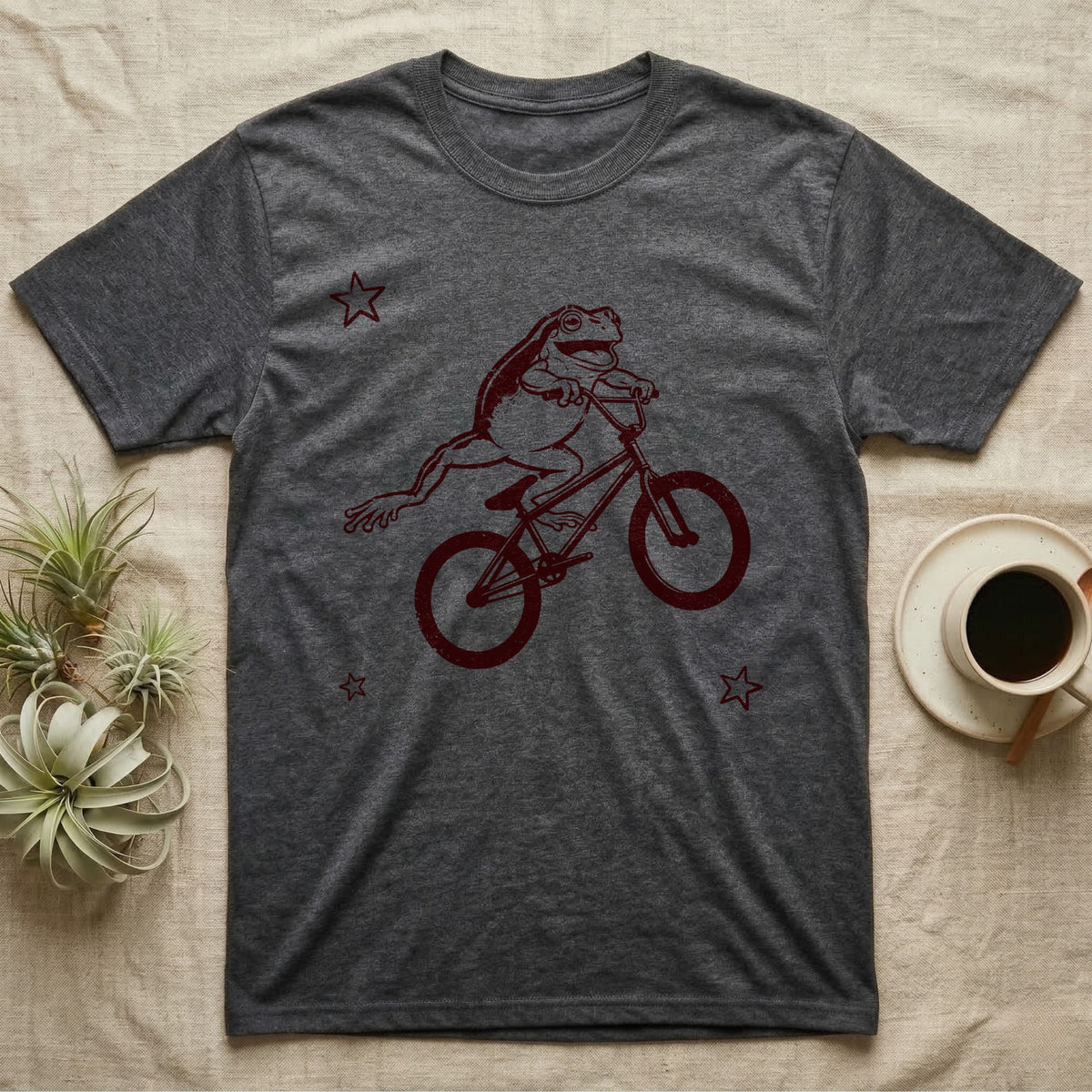 Tree Frog Can-Can T-Shirt in Dark Heather — Distressed one-ink oxblood screenprint of a White's tree frog airborne on a BMX bike, both back legs kicked off the pedals and swung to one side, hands still on the bars.