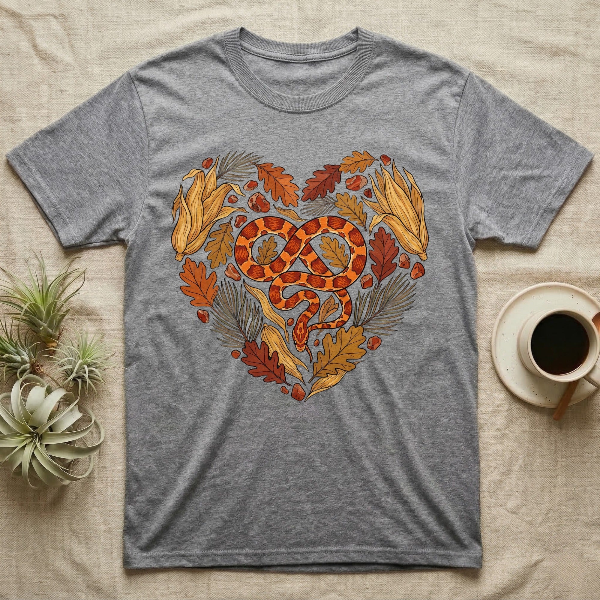 Grey t-shirt with a heart-shaped design of a snake and autumn leaves.
