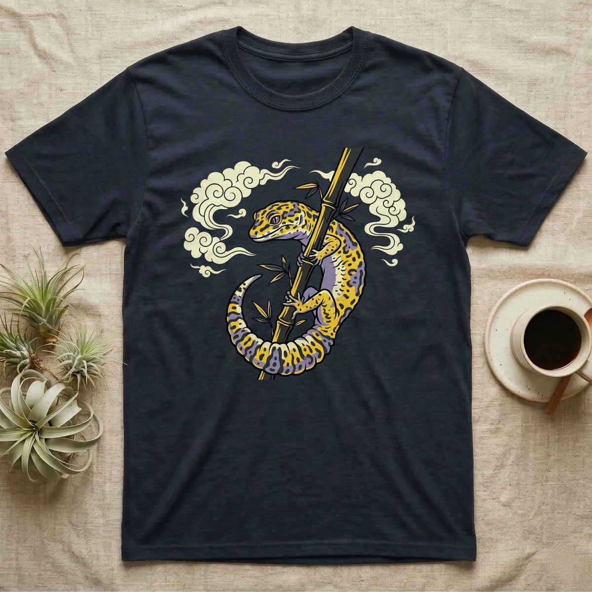 Dark t-shirt with illustration of a gecko climbing a bamboo stalk.
