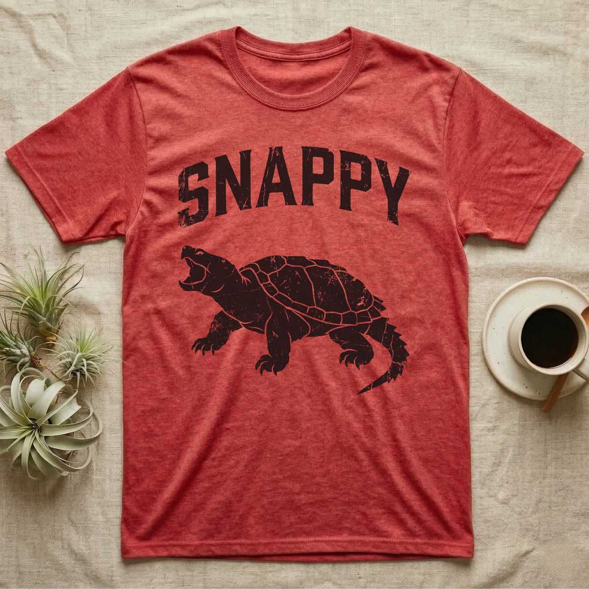 Snapping Turtle Snappy T-Shirt in Heather Red — Worn one-ink print of a common snapping turtle crouched side-on, jaws open mid-snap, under the arched word SNAPPY