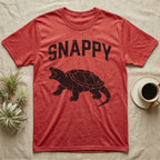 Snapping Turtle Snappy T-Shirt in Heather Red — Worn one-ink print of a common snapping turtle crouched side-on, jaws open mid-snap, under the arched word SNAPPY