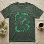 Green Iguana Cosmic T-Shirt in Military Green — Vintage screen-print illustration of green iguanas in astronaut helmets floating in space, cosmic emerald green monochromatic on dark background.