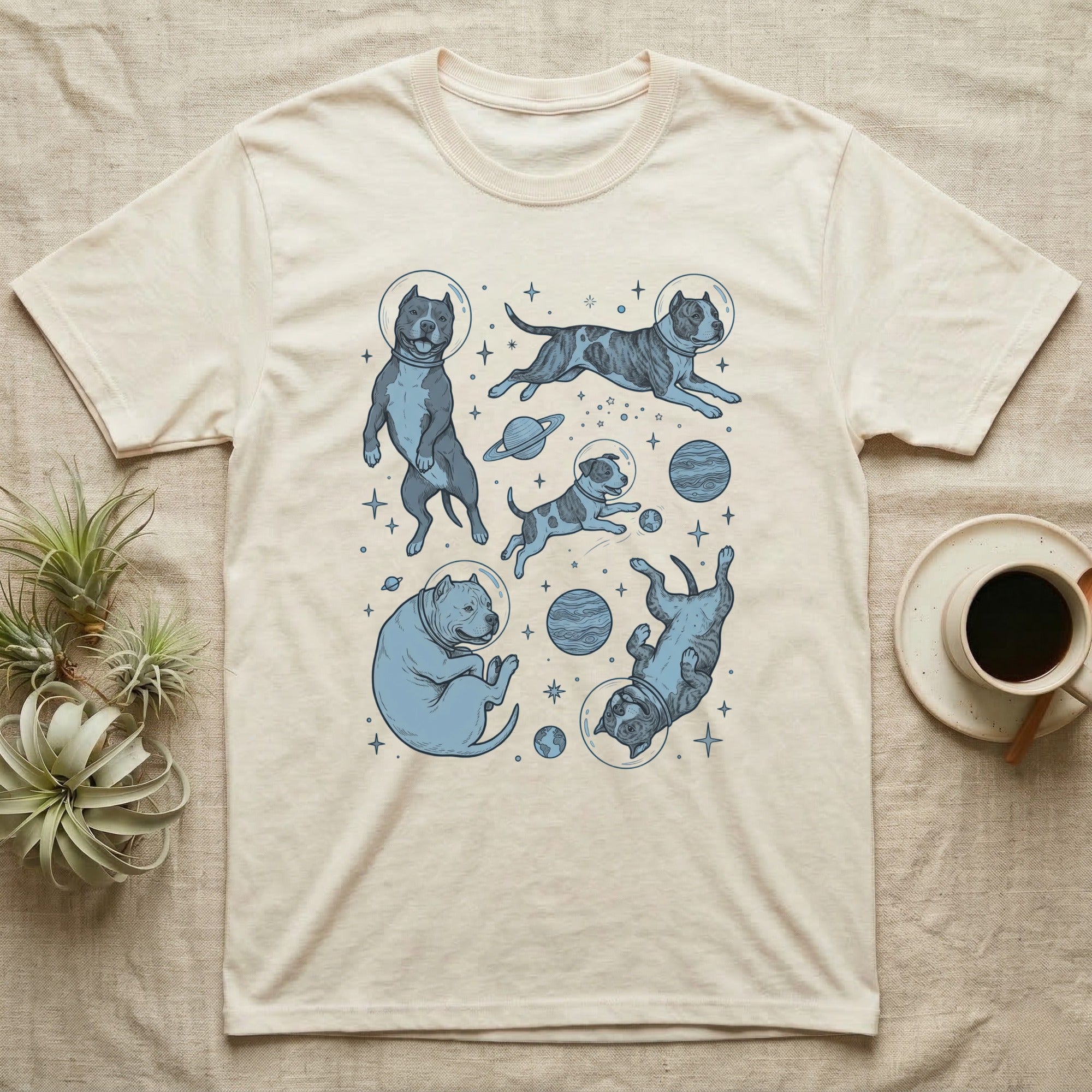 Cream t-shirt with blue cartoon dogs in outer space.