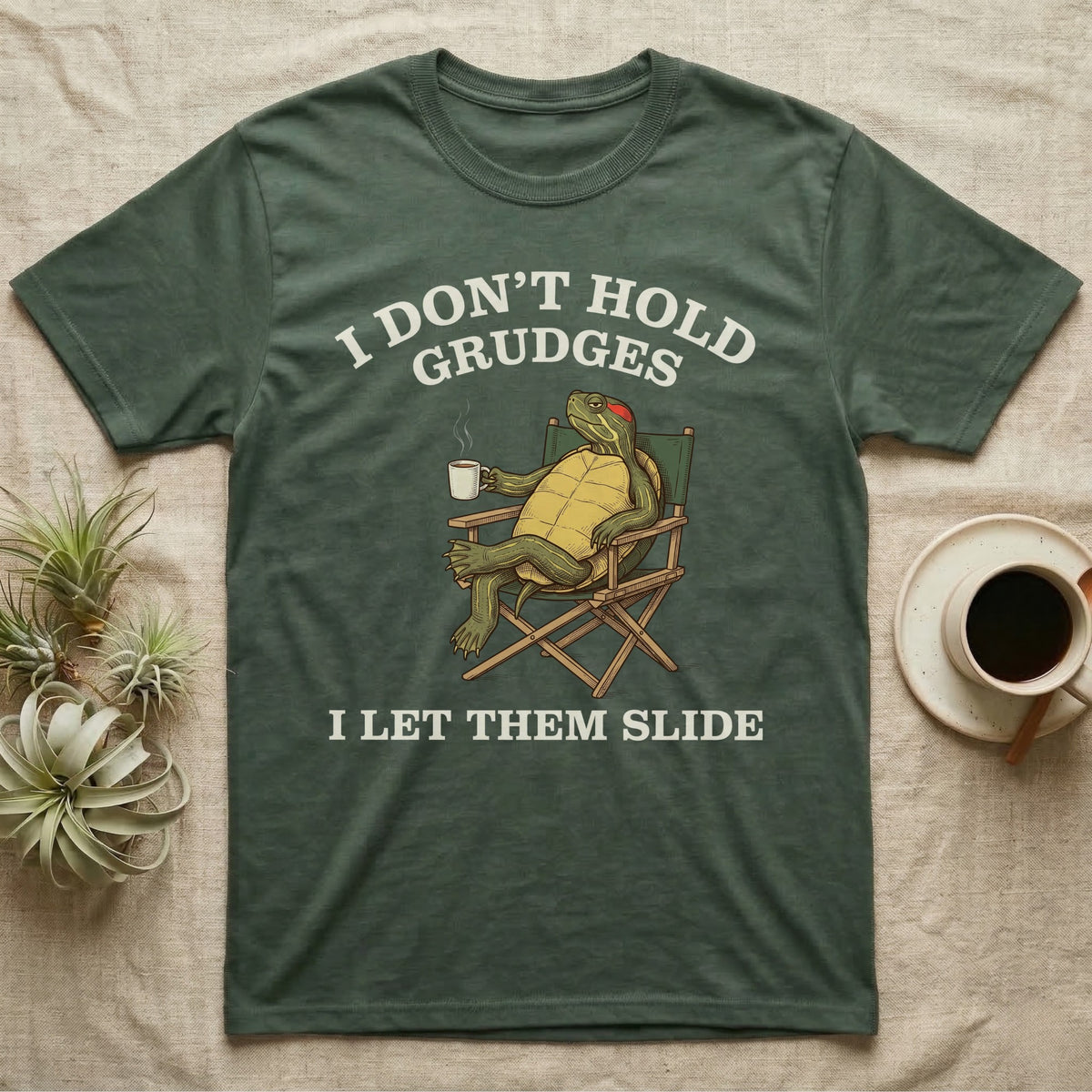 Red-Eared Slider Grudges T-Shirt in Military Green — Engraved red-eared slider lounging in a camp chair with tea under I Don't Hold Grudges I Let Them Slide