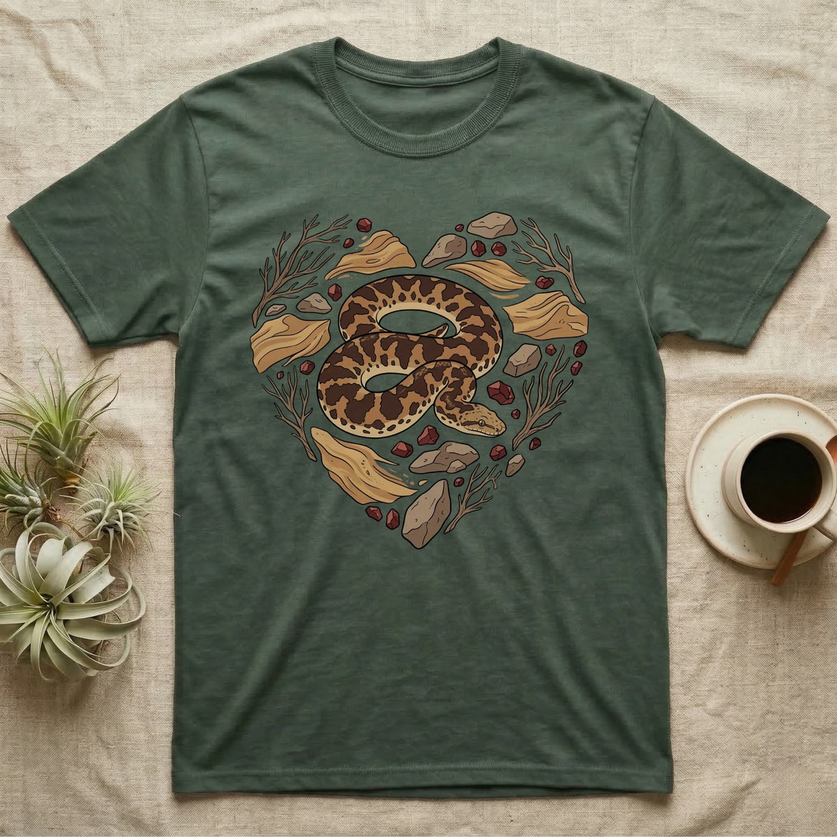 Green t-shirt with a snake and stones forming a heart shape.