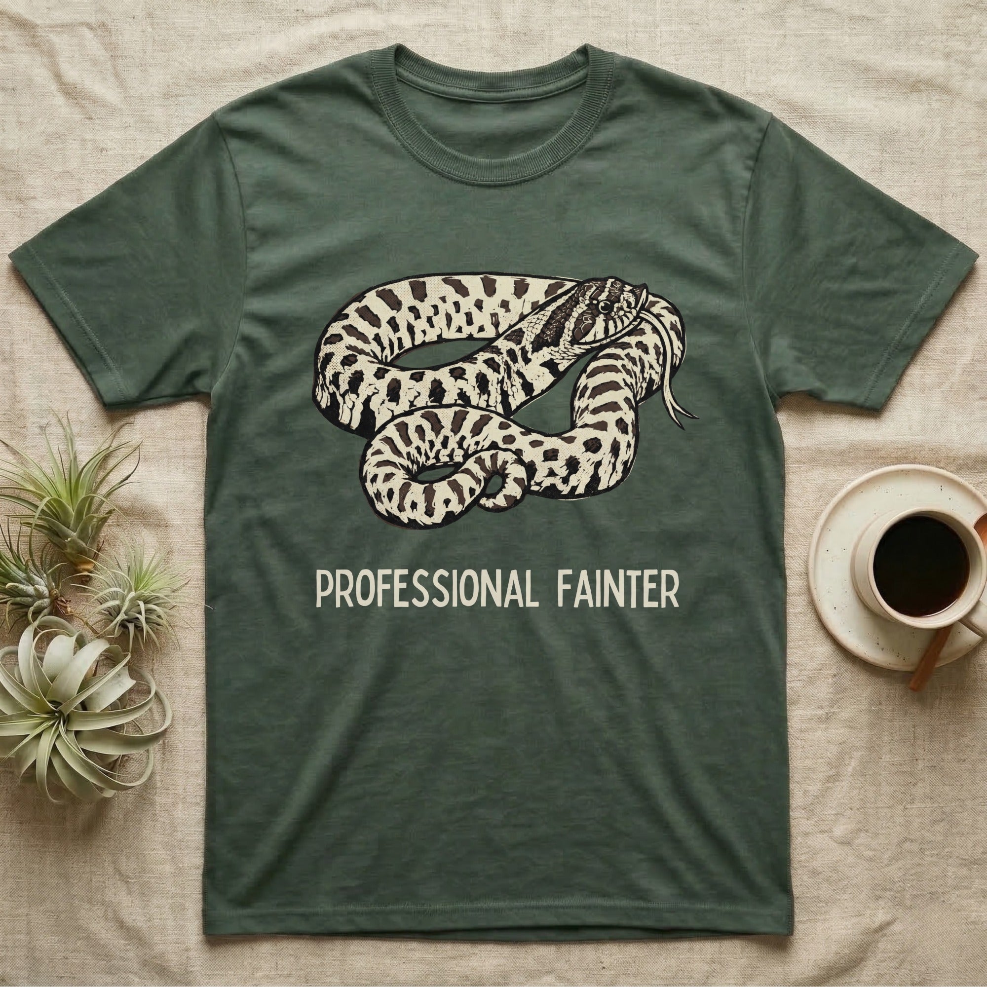 Hognose Professional Fainter T-Shirt in Military Green — Linocut block-print of a western hognose snake flopped belly-up in a death-feign with professional fainter caption.