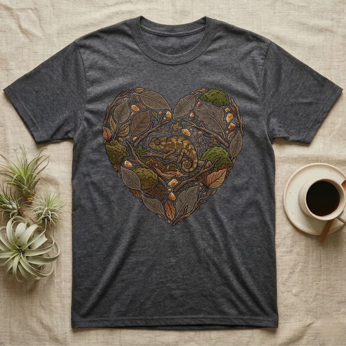 Dark grey t-shirt featuring a heart-shaped illustration of a chameleon amongst autumn leaves and acorns.