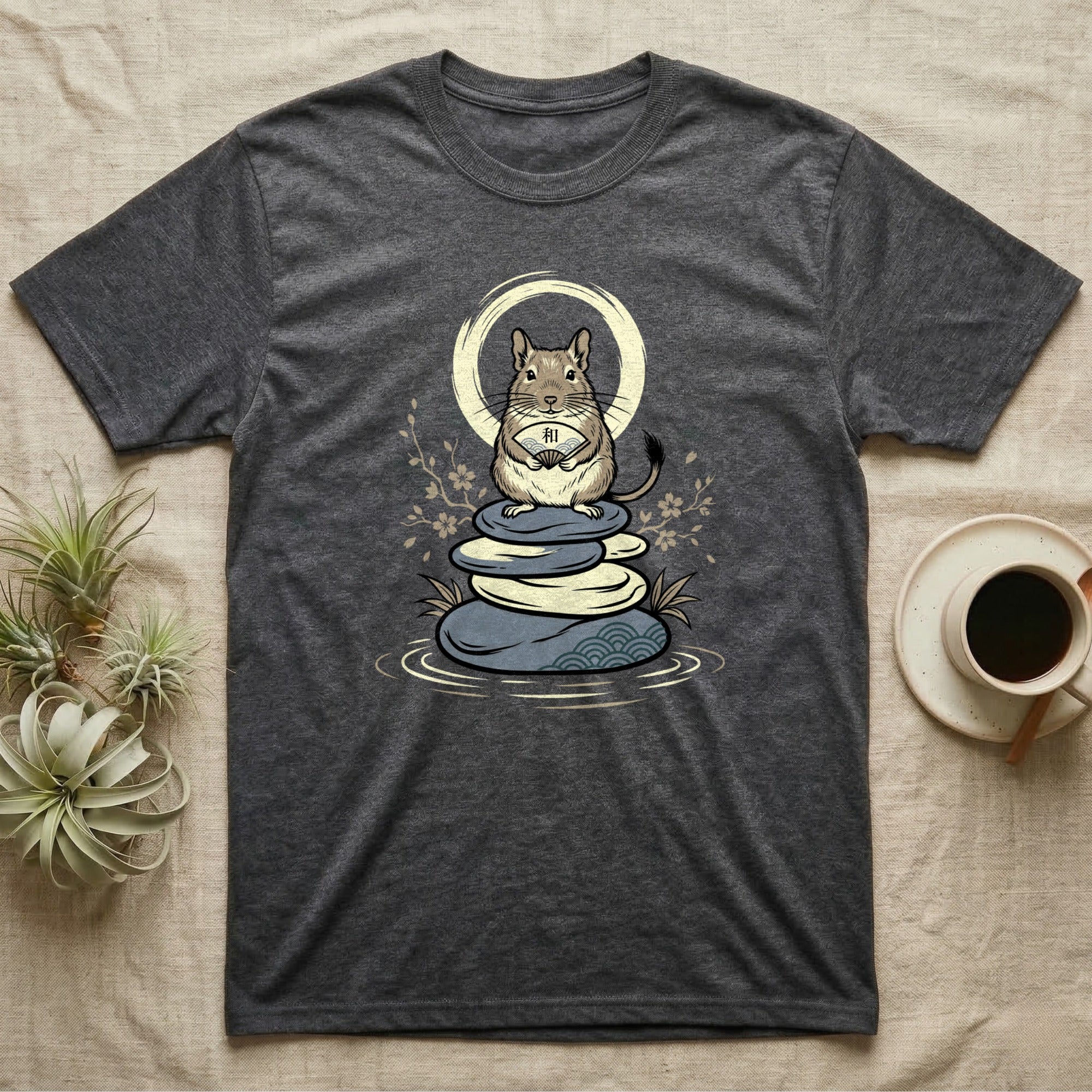 Dark grey t-shirt with a graphic of a rodent holding a fan on stacked stones.