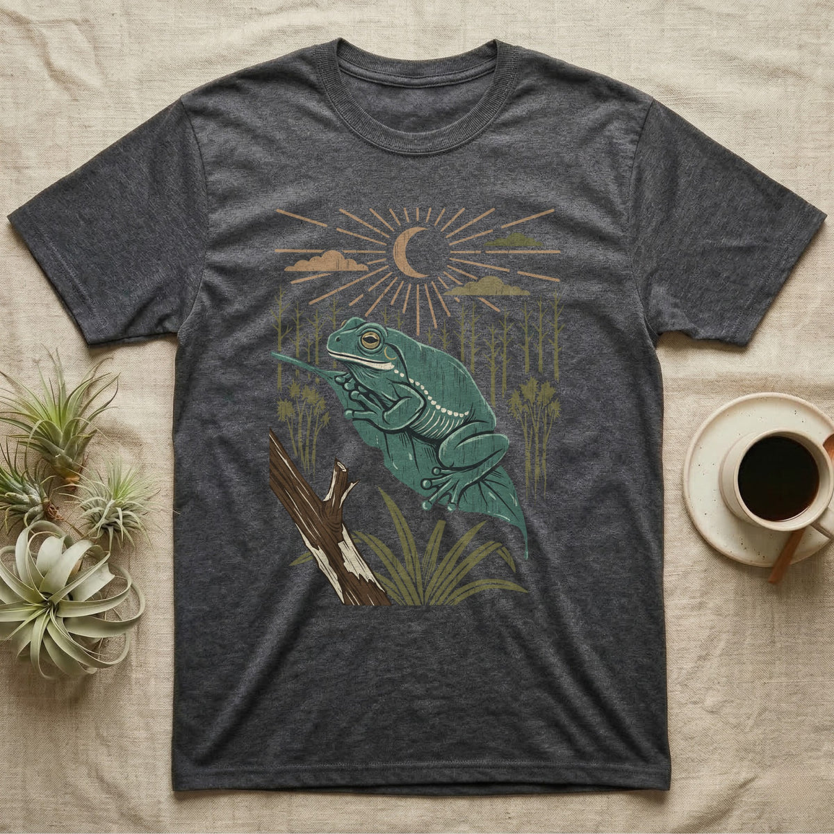 White's Tree Frog Home Range T-Shirt in Dark Heather — Woodcut-style illustration of a White's tree frog resting on a broad wet leaf with reed stems and a crescent moon behind, no on-shirt text.