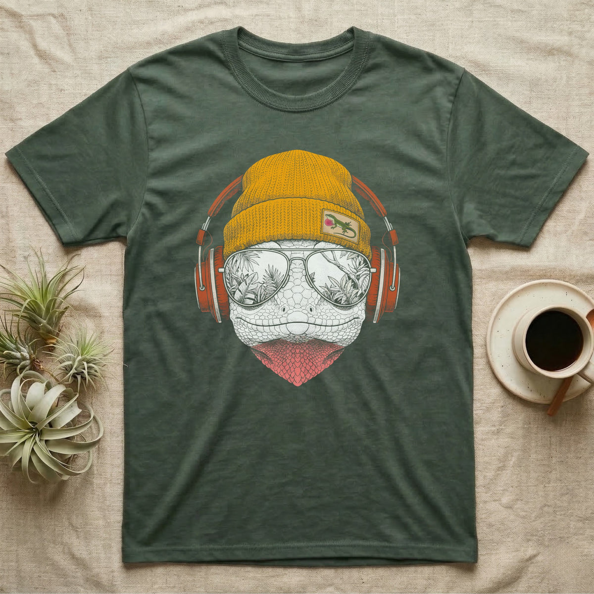 Green Anole Chill Beats T-Shirt in Military Green — Engraved green anole with pink dewlap showing, in a beanie and headphones, aviators reflecting tropical palms.
