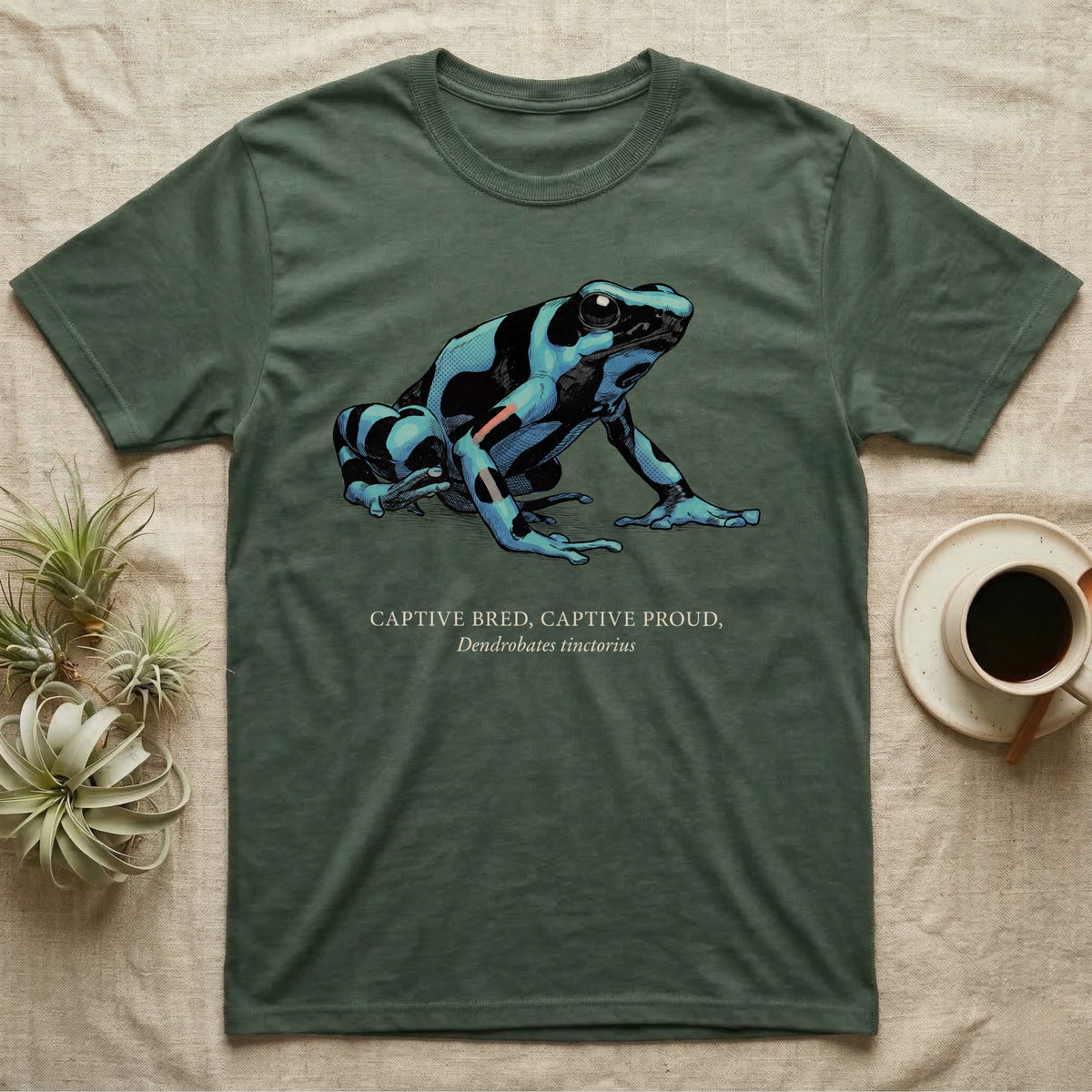 Captive Bred Frog T-Shirt in Military Green — Naturalist-plate illustration of a healthy dyeing dart frog above a serif creed reading Captive Bred Captive Proud.