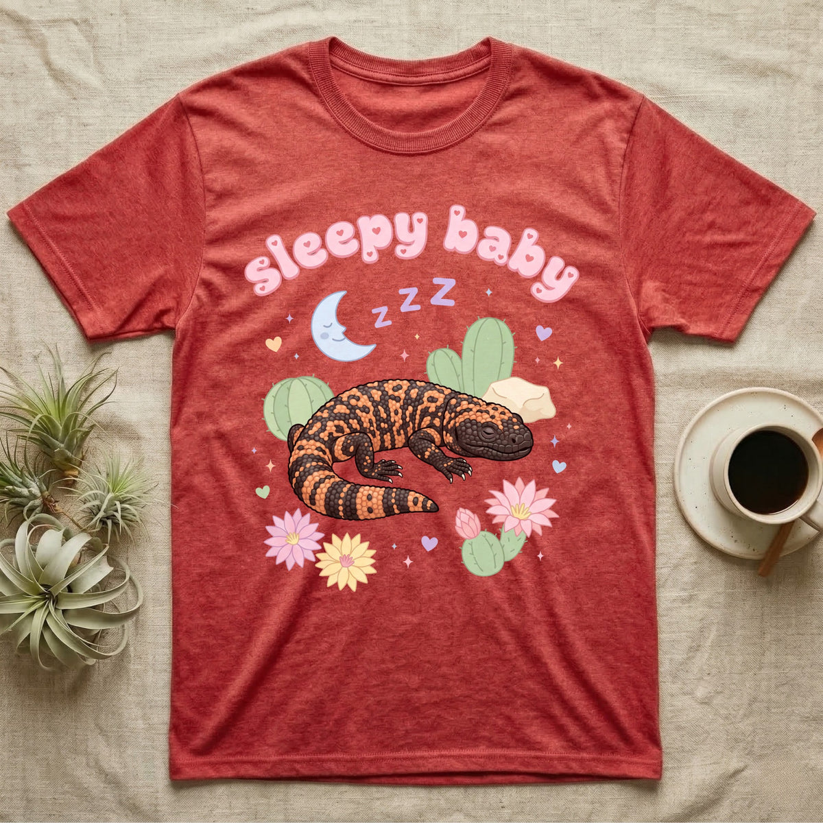 Gila Monster Baby T-Shirt in Heather Red — Pastel Gila monster with sleepy eyes, crescent moon and Z Z Z, puffy salmon bubble wordmark "sleepy baby" above.