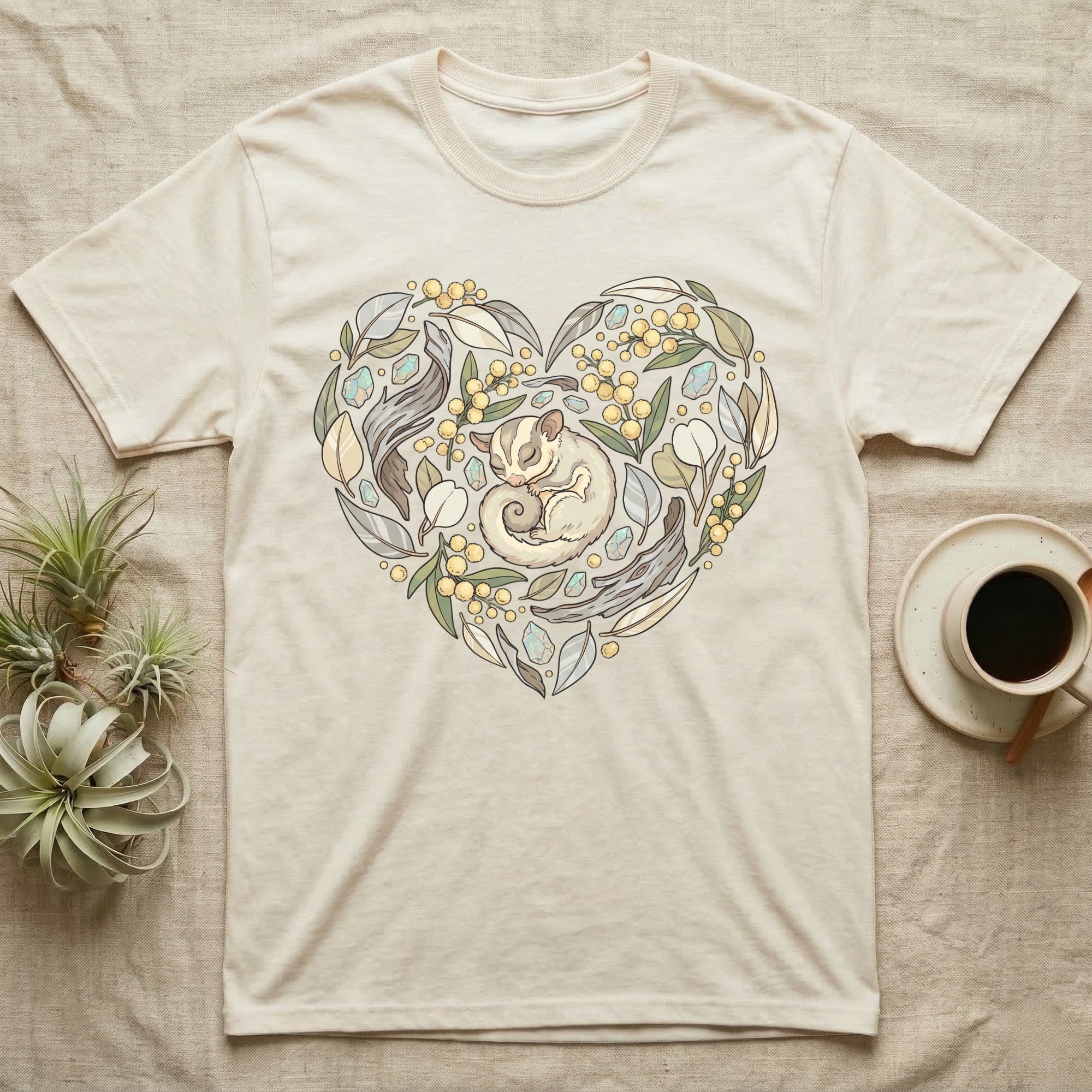 Cream t-shirt with sleeping sugar glider in a heart-shaped floral design.