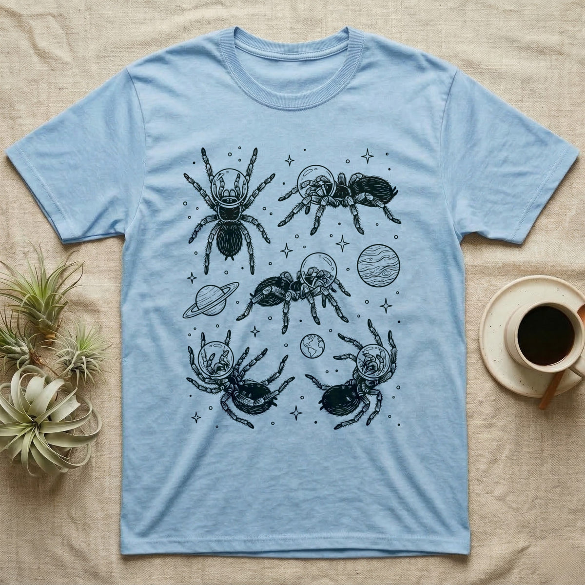 Tarantula Cosmic T-Shirt in Light Blue — Vintage screen-print illustration of tarantulas in astronaut helmets floating in space, obsidian black monochromatic on dark grey background.