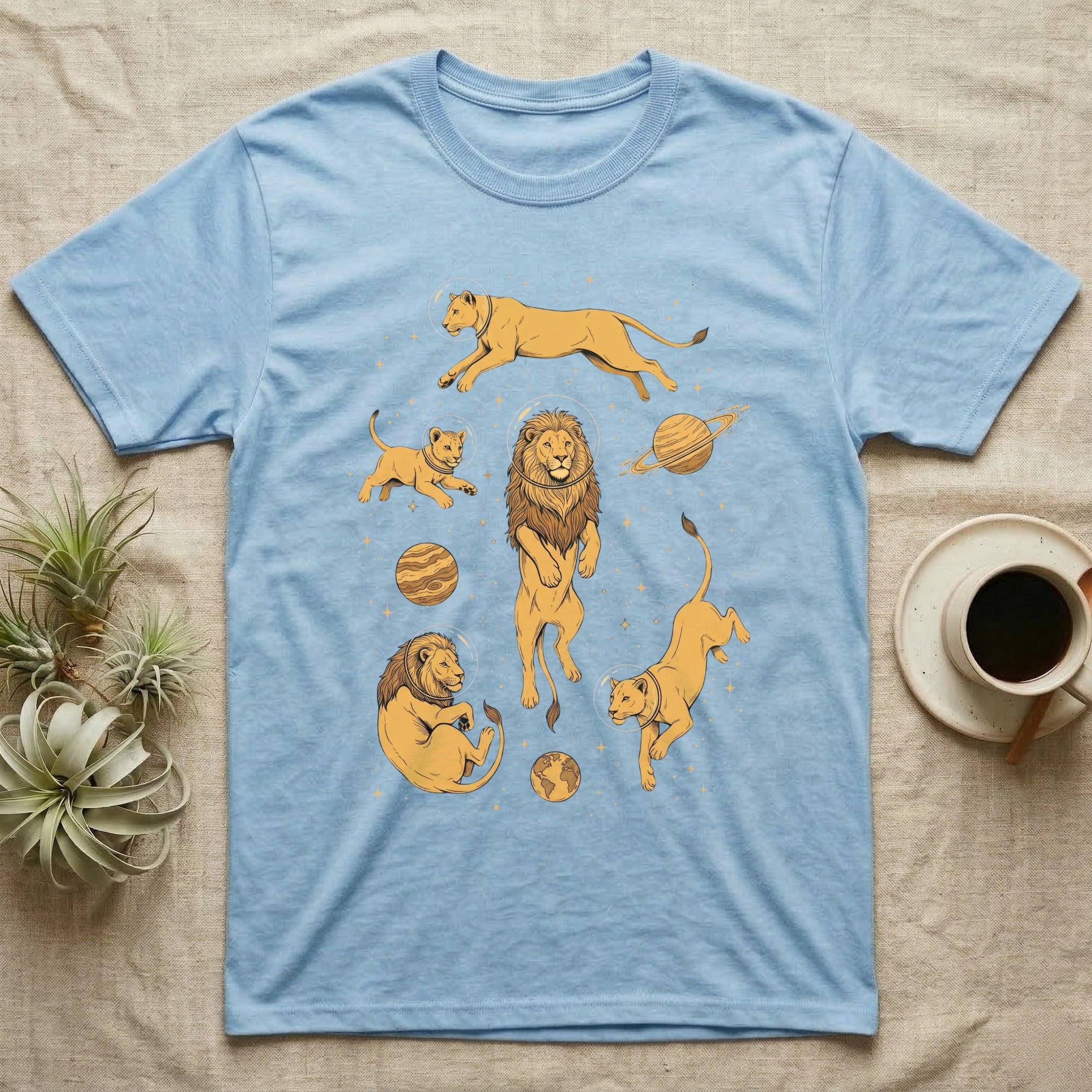 Light blue t-shirt with illustrations of lions and planets in space.