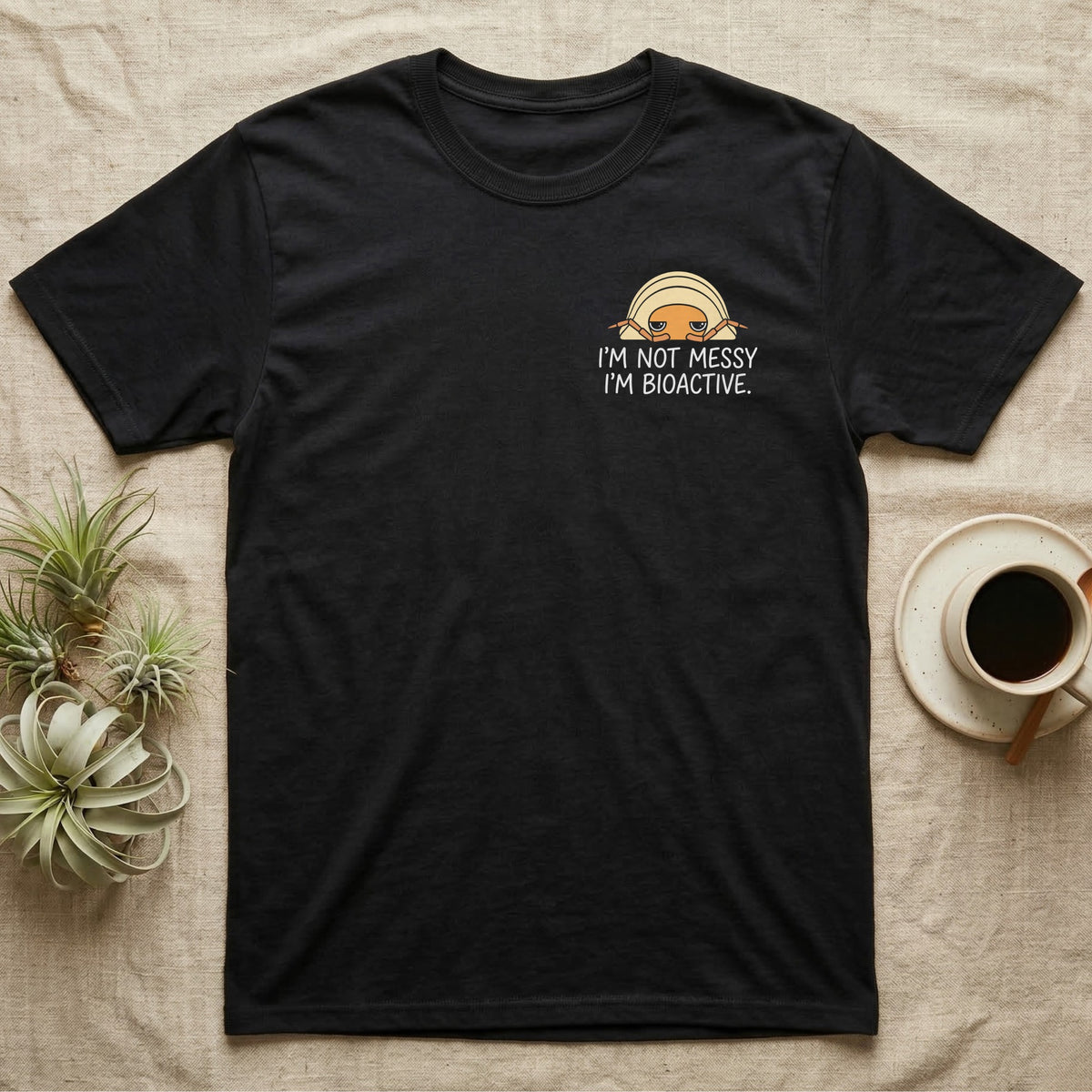 Bioactive Rubber Ducky T-Shirt in Black — Creamy-yellow rubber ducky isopod with an orange face peeking over white marker capitals reading I'M NOT MESSY I'M BIOACTIVE.