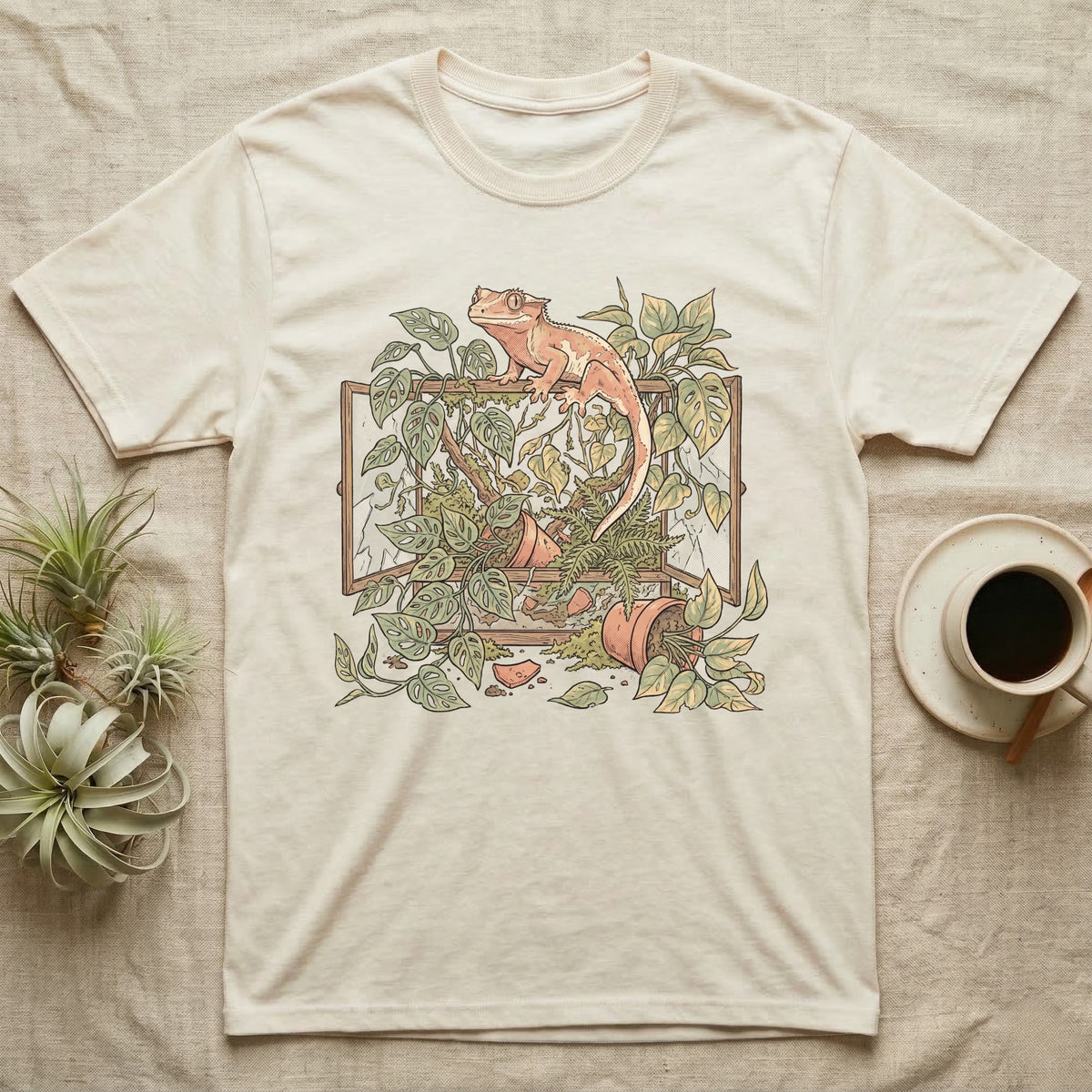 Bioactive Crested Gecko T-Shirt in Natural — Botanical illustration of a smug crested gecko perched atop a lush overgrown planted vivarium spilling vines.
