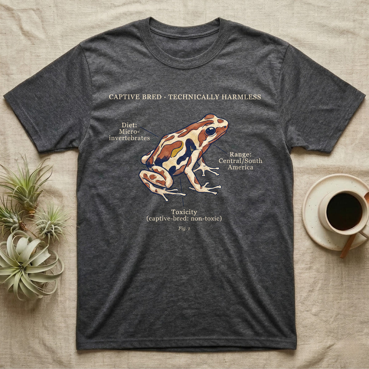 Captive Bred Dart Frog T-Shirt in Dark Heather — Retro science-plate illustration of a labeled dart frog with field-guide callouts and a captive-bred non-toxic note.