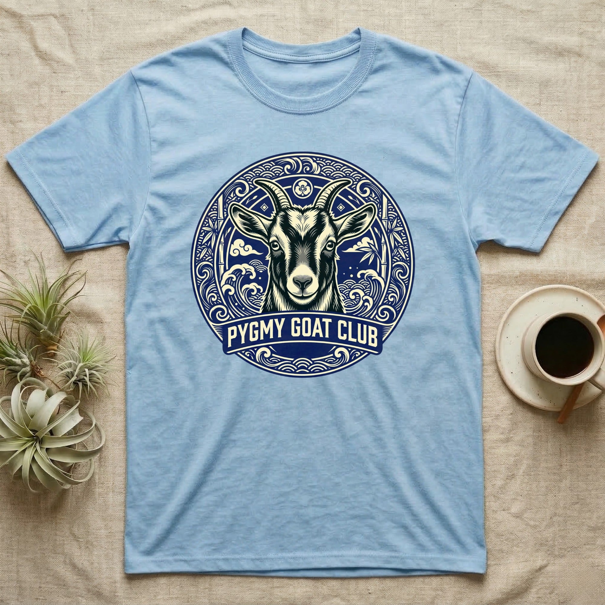 Light blue t-shirt with a circular pygmy goat graphic and text.