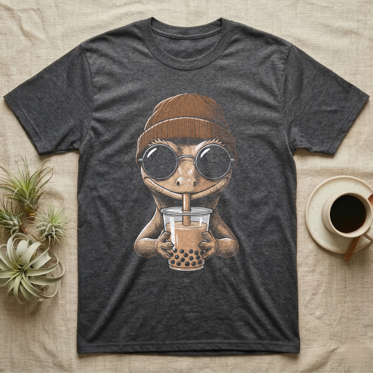 Crested Gecko Boba Tea T-Shirt in Dark Heather — Cross-hatch engraving of a crested gecko in a beanie and round glasses sipping boba milk tea.