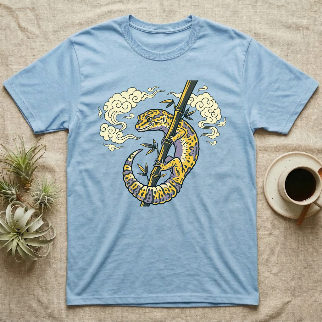 Light blue t-shirt with a yellow gecko on a bamboo stalk illustration.
