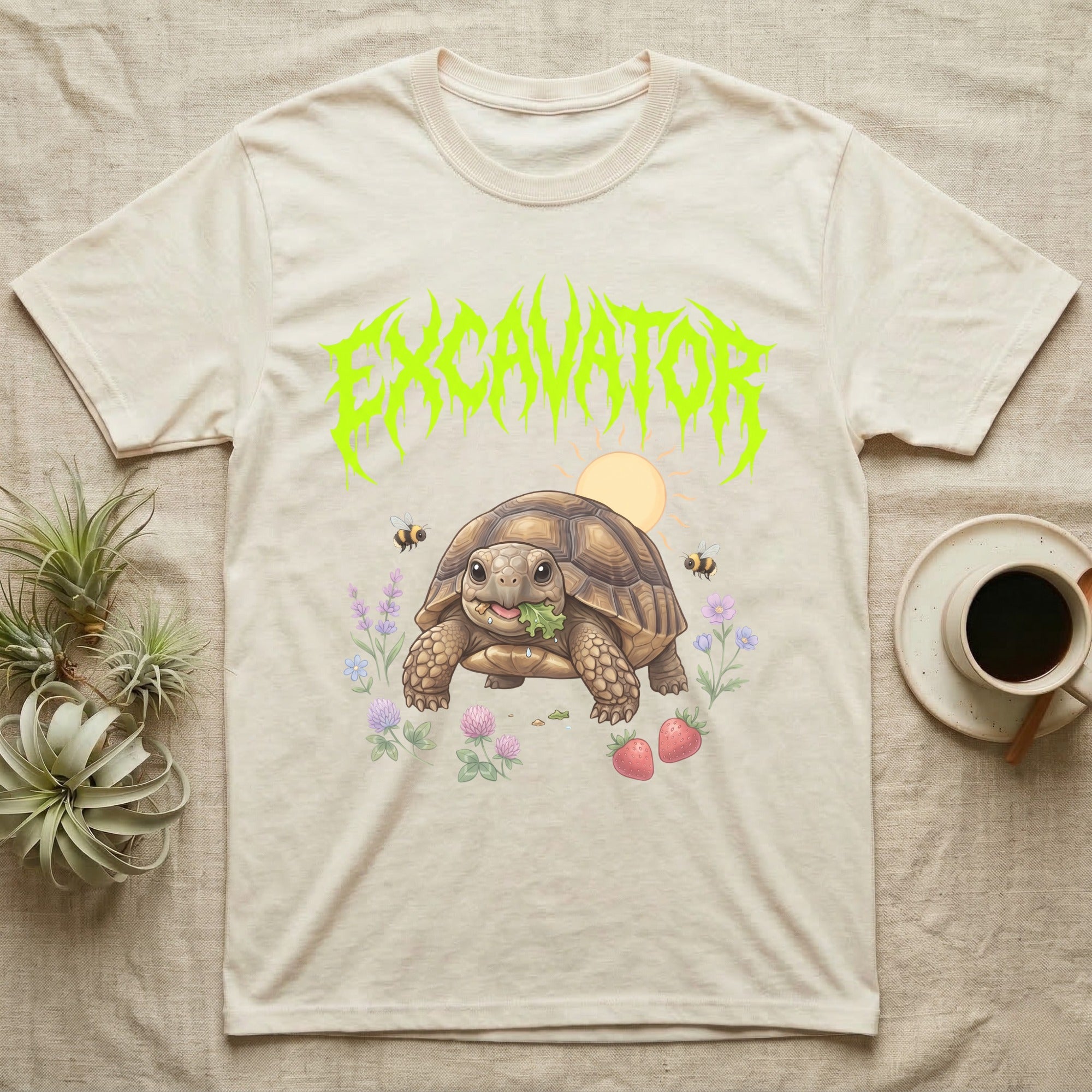 Russian Tortoise Feral T-Shirt in Natural — Chubby Russian tortoise munching a green in a pastel meadow under a spiky lime metal wordmark reading EXCAVATOR.