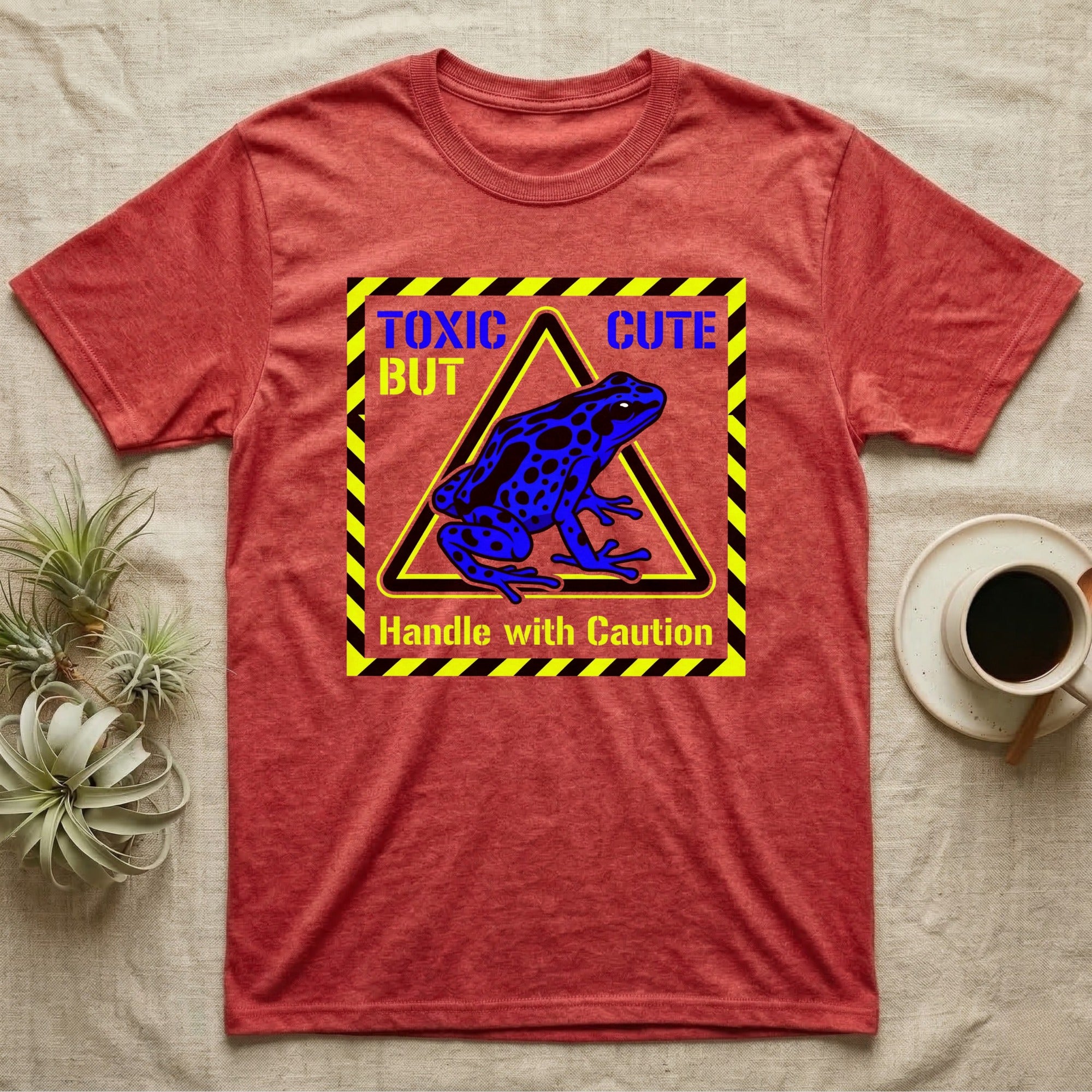 Red t-shirt with blue frog design and "TOXIC BUT CUTE. HANDLE WITH CAUTION." text.