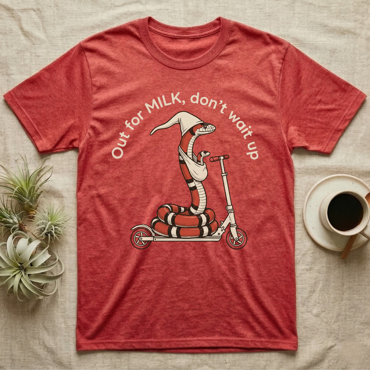 Milk Snake Scooter T-Shirt in Heather Red — Milk snake in a white cap riding a kick scooter with a baby snake in a sling, under the curved words Out for MILK, don't wait up.