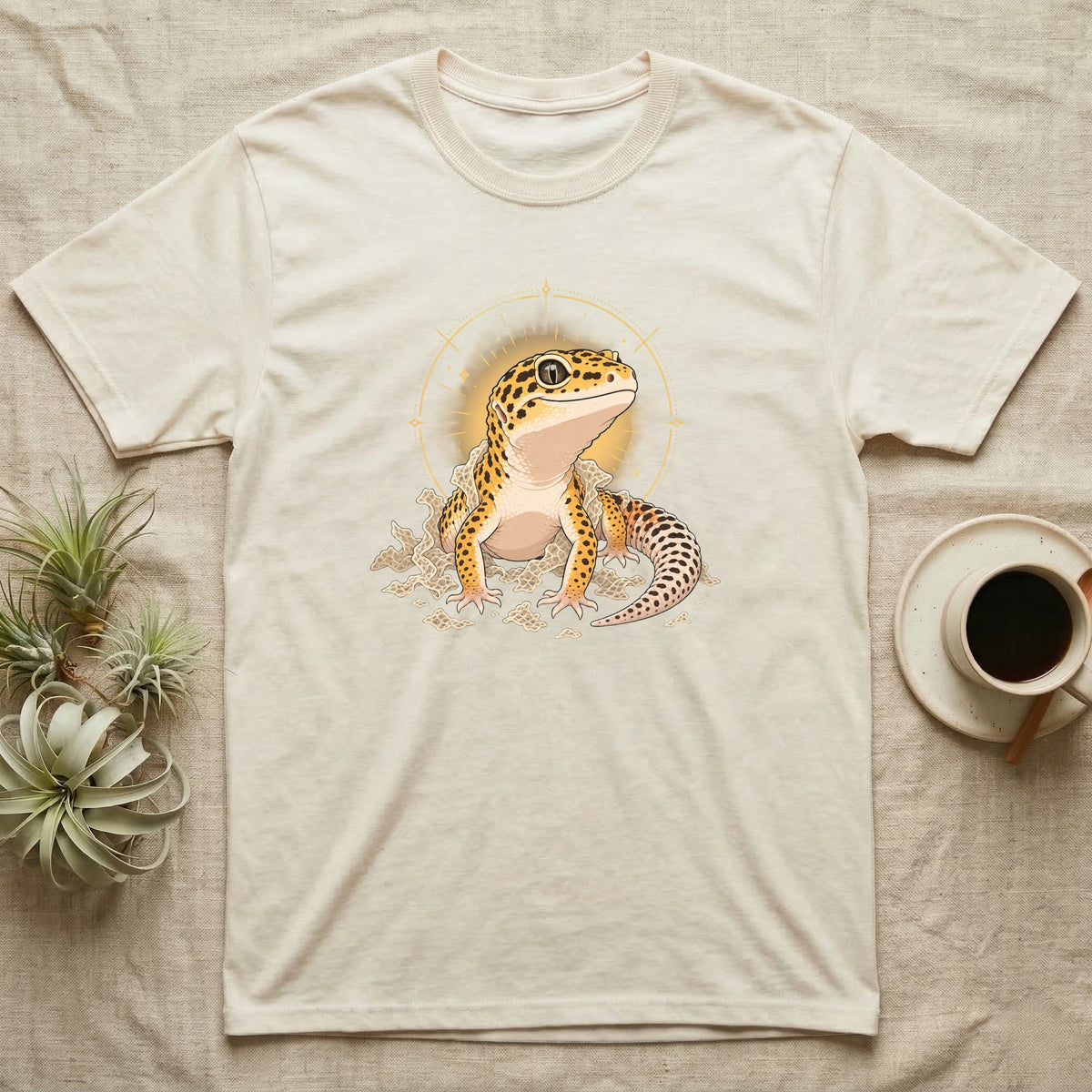 Leopard Gecko Shed T-Shirt in Natural — Bold vector illustration of a leopard gecko emerging fresh from a shed, lit by a soft warm halo glow.