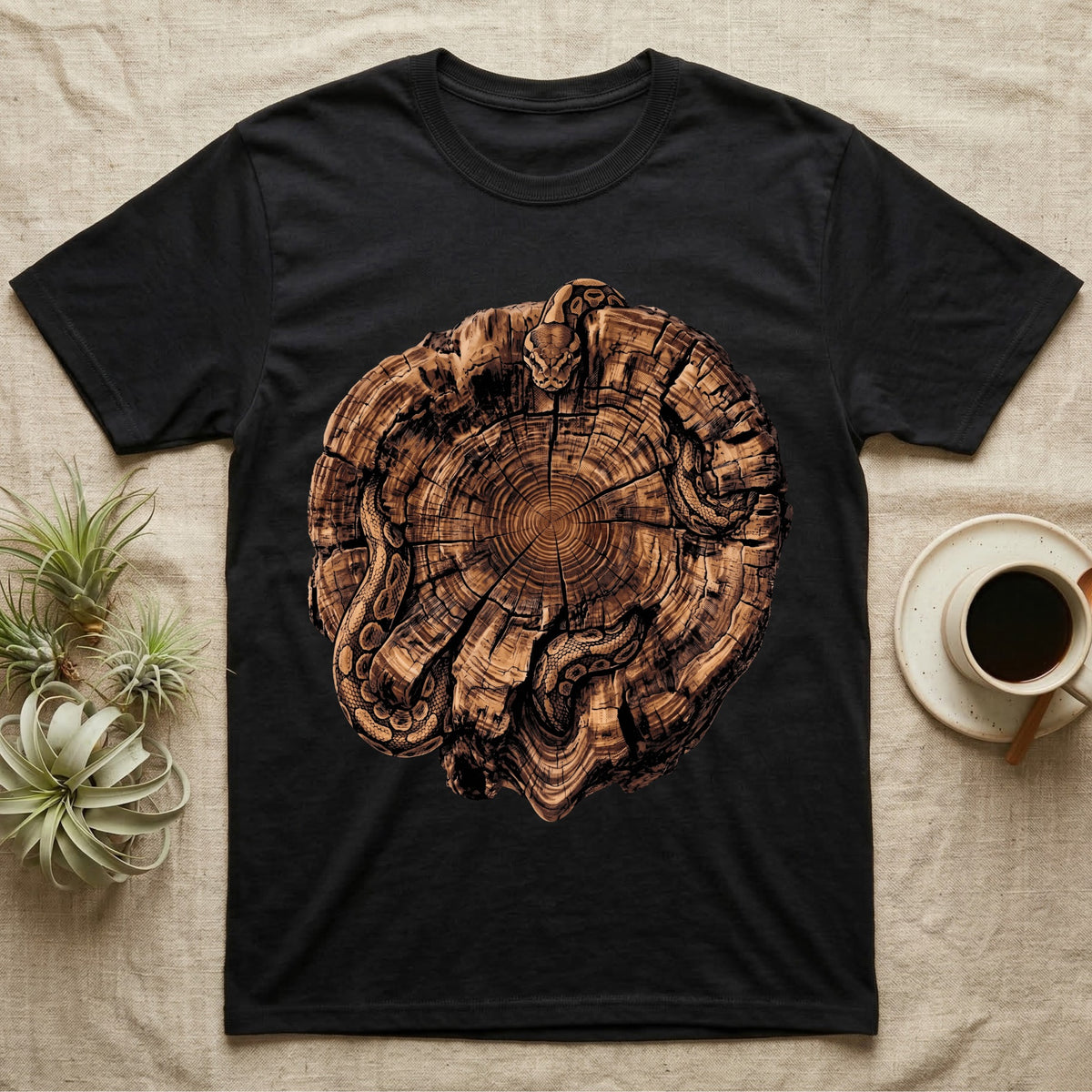 Ball Python Stump Coil T-Shirt in Black — Pyrography-style illustration of a ball python threaded through the charred radial cracks of a cross-section log, no on-shirt text.
