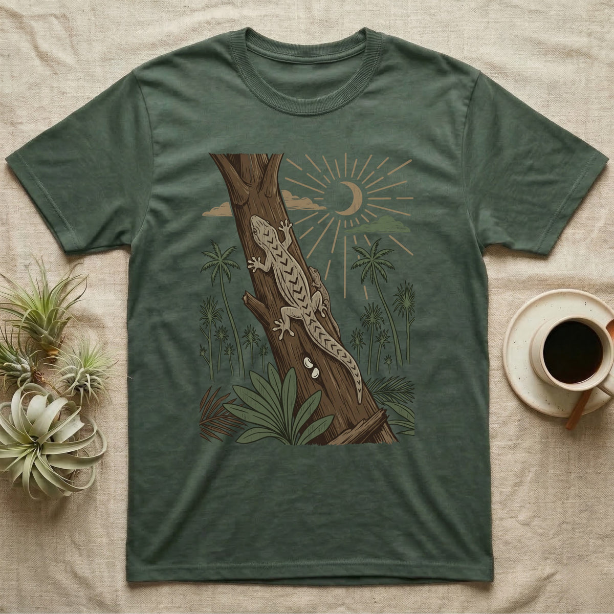 Mourning Gecko Home Range T-Shirt in Military Green — Woodcut-style illustration of two mourning geckos on a palm trunk with a pair of eggs in the bark and palms behind, no on-shirt text.