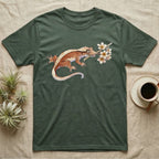 Crested Gecko Blossom T-Shirt in Military Green — Watercolor illustration of a rust-brown crested gecko holding a frangipani blossom sprig, on a dark grey t-shirt.
