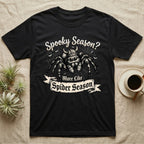 Jumping Spider Viking Helmet T-Shirt in Black — Ink-sketch jumping spider in a Viking helmet over a web, banner reading "More Like Spider Season."