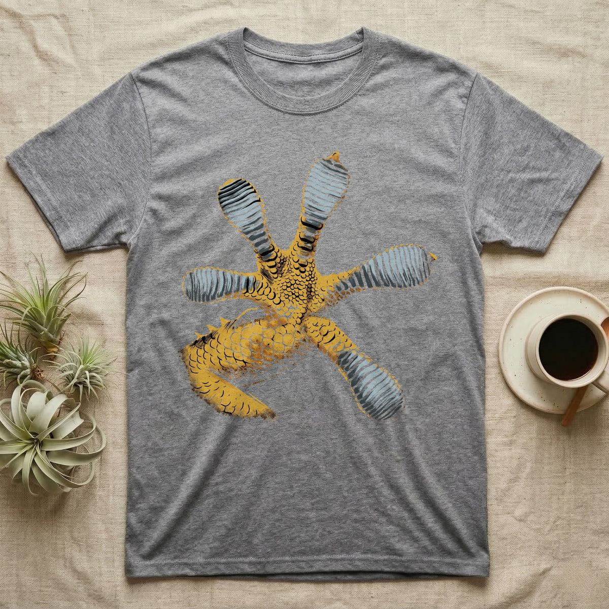 Macro illustration of a gecko's forefoot from underneath, ribbed blue-grey lamellae toe pads fanned against amber-gold scale texture, no on-shirt text. — shown on a Sport Grey tee.