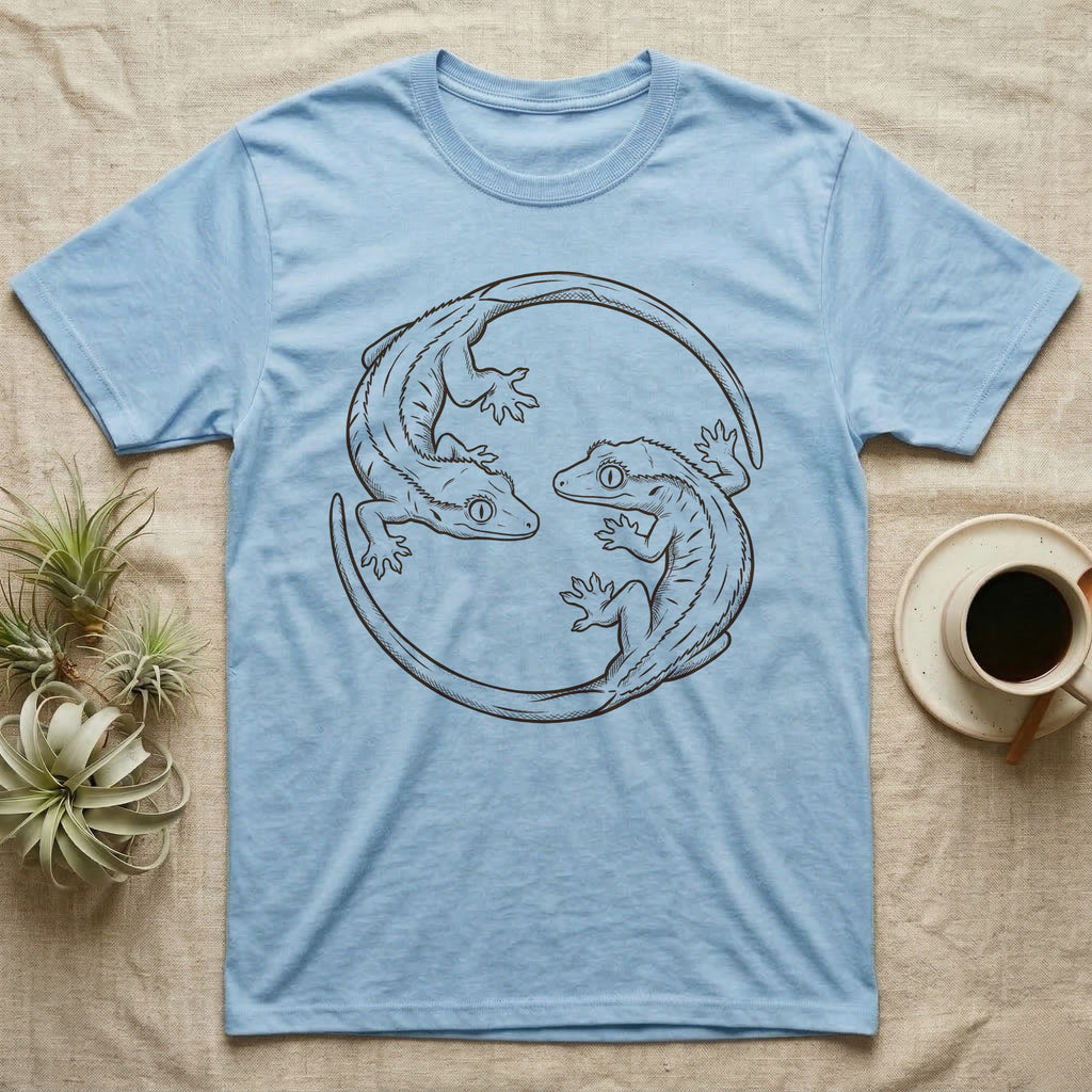 Crested Gecko Roundel T-Shirt in Light Blue — Two crested geckos in mahogany brush line art, rotated 180 degrees into a circular roundel closed by their own tails.