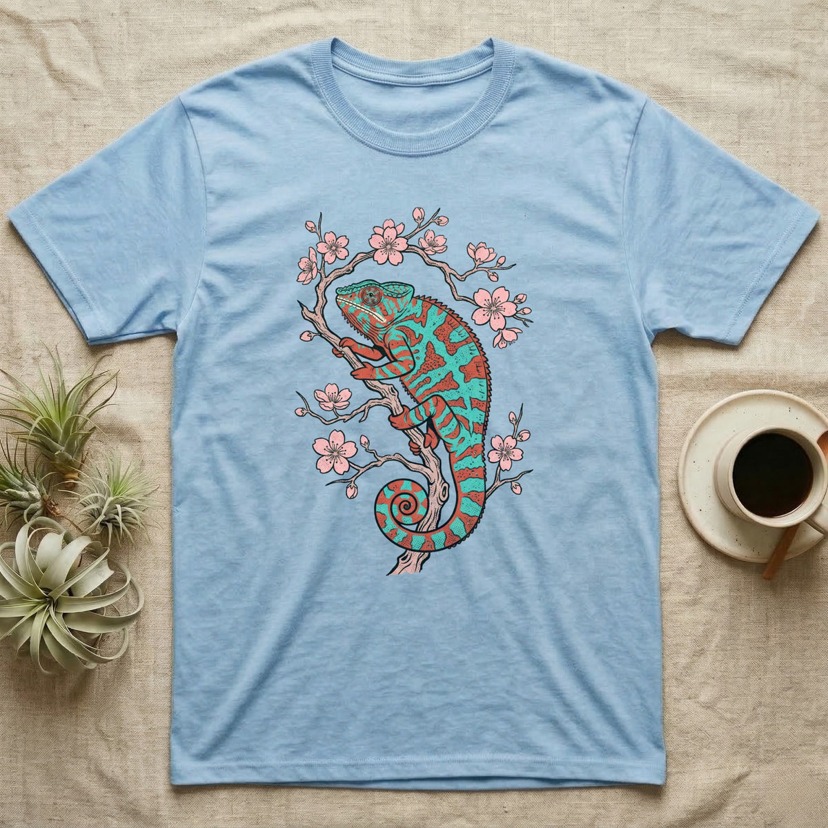 Blue t-shirt with a teal and orange chameleon on a cherry blossom branch.