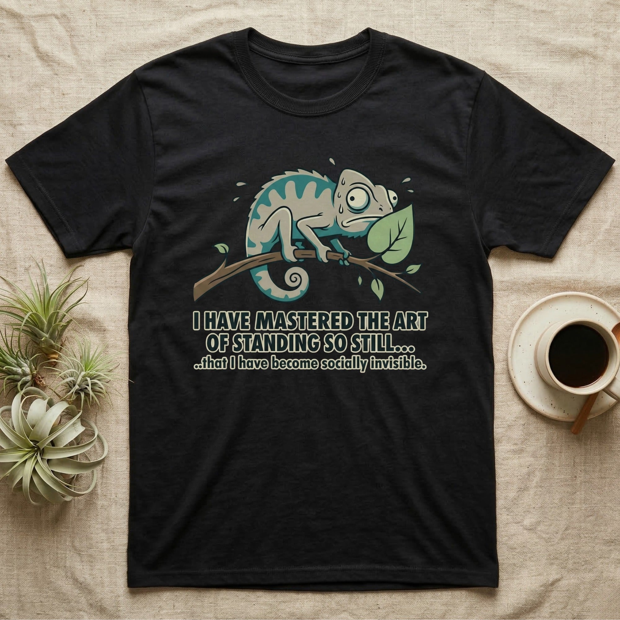 Black t-shirt with a chameleon on a branch and humorous text about invisibility.