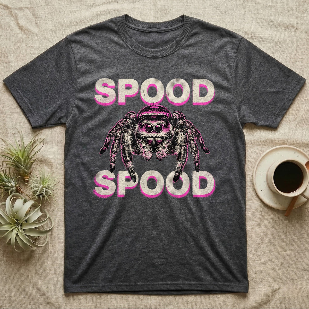 Spood Jumping Spider T-Shirt in Dark Heather — Grunge-punk illustration of an oversized front-facing jumping spider with a distressed "Spood" wordmark in bone and acid pink.