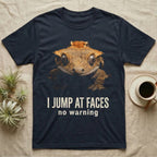 Photographic mugshot of a crested gecko braced wide-eyed above the hook I Jump At Faces, no warning. — shown on a Navy tee.