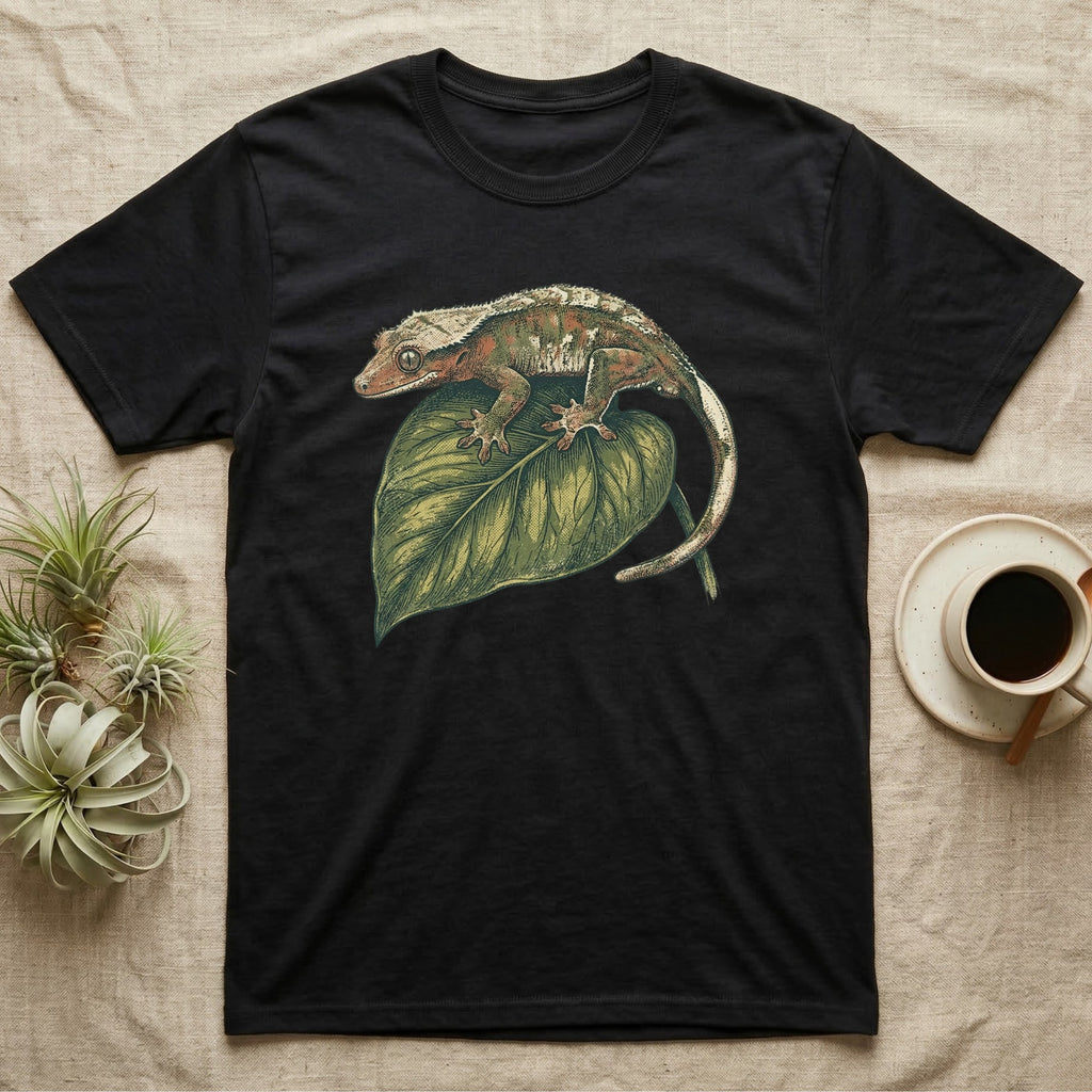 Black t-shirt with a crested gecko on a green leaf design.