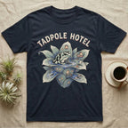 Tadpole Hotel Frog T-Shirt in Navy — Whimsical naturalist illustration of a dart frog tucking tadpoles into a bromeliad Tadpole Hotel with hand-lettered marquee text.