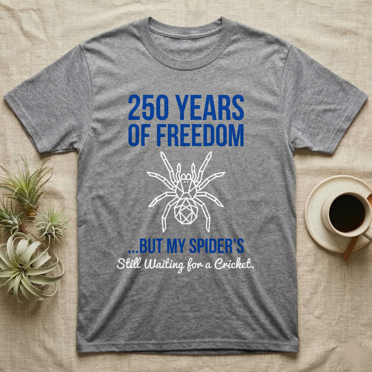 Tarantula Waiting For Cricket Tee in Sport Grey — Minimalist geometric tee with a low-poly white tarantula and blue text reading 250 Years Of Freedom but my spider's still waiting for a cricket.