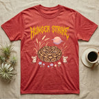Ball Python Feral T-Shirt in Heather Red — Ball python coiled in a loaf in a pastel savanna scene under a spiky honey-gold metal wordmark reading HUNGER STRIKE.