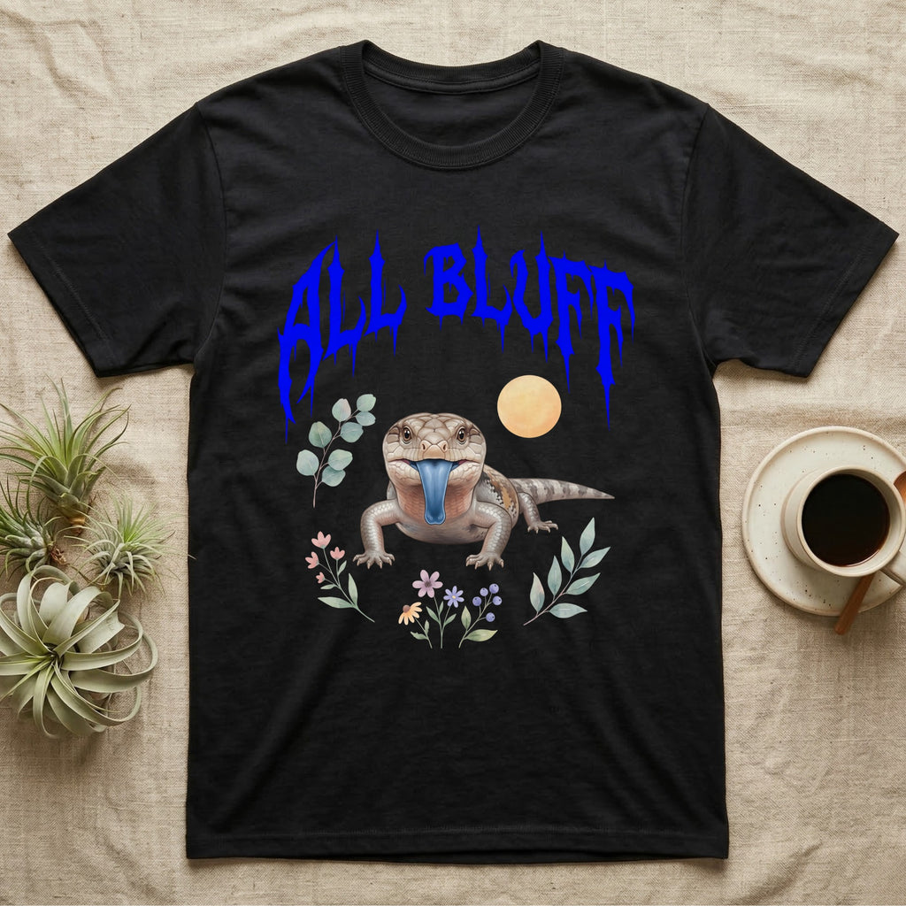 Northern Blue-Tongue Skink Feral T-Shirt in Black — Blue-tongue skink with its blue tongue out under a jagged cobalt-blue metal "ALL BLUFF" wordmark and pastel leaves.