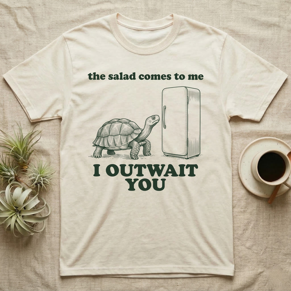 Sulcata Fridge Standoff T-Shirt in Natural — Engraved sulcata tortoise waiting in front of a closed fridge between the words the salad comes to me and I OUTWAIT YOU.