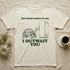 Sulcata Fridge Standoff T-Shirt in Natural — Engraved sulcata tortoise waiting in front of a closed fridge between the words the salad comes to me and I OUTWAIT YOU.