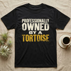 Owned By A Tortoise T-Shirt in Black — Distressed woodtype wordmark reading professionally owned by a tortoise in a bold two-tier lockup, text only.