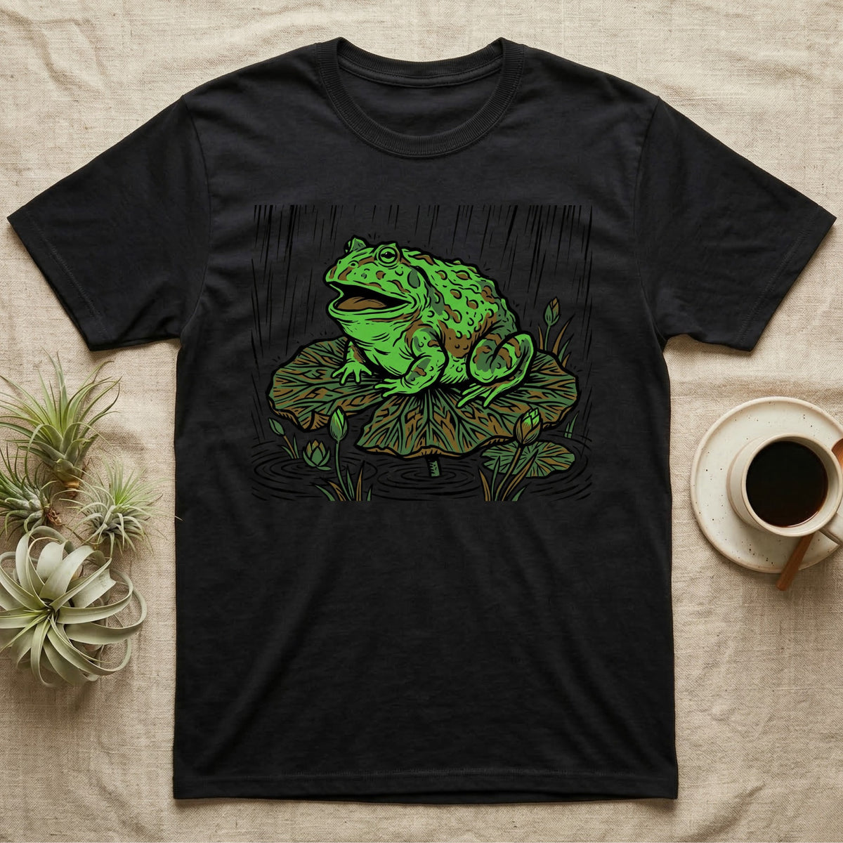 Black t-shirt with a green frog sitting on a lily pad.