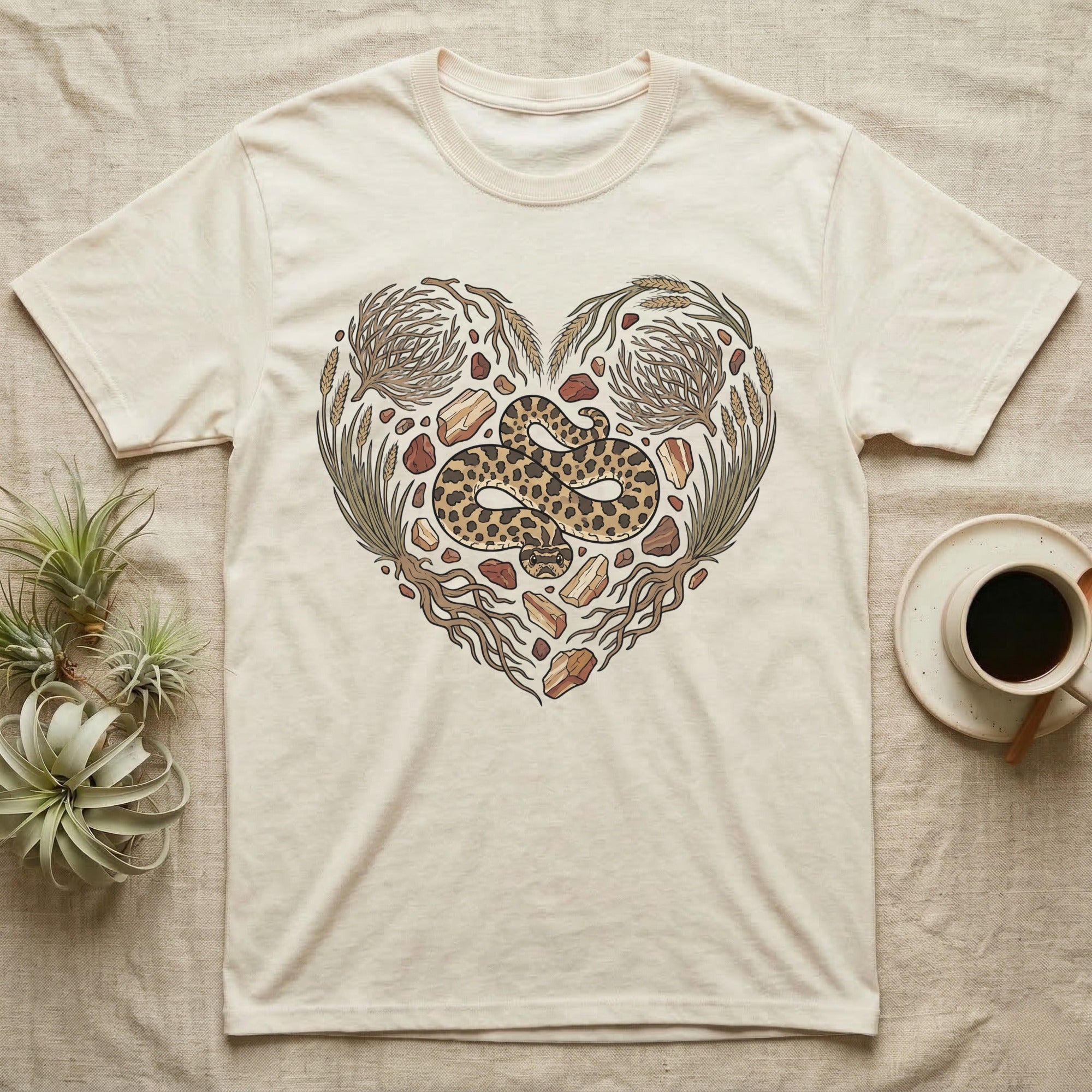 Cream t-shirt with a heart-shaped design of a rattlesnake and natural elements.