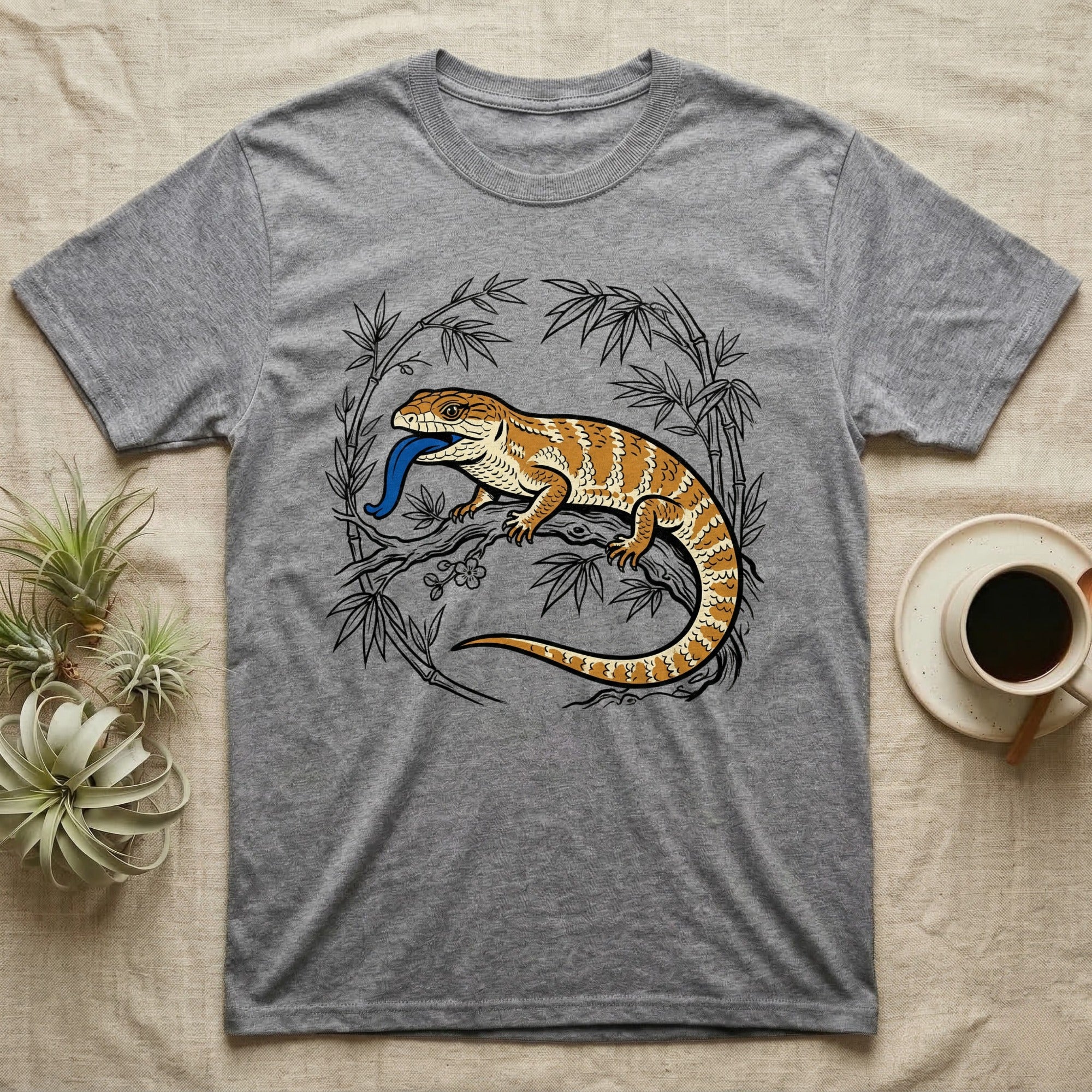 Grey t-shirt with illustrated bearded dragon and blue tongue among bamboo.